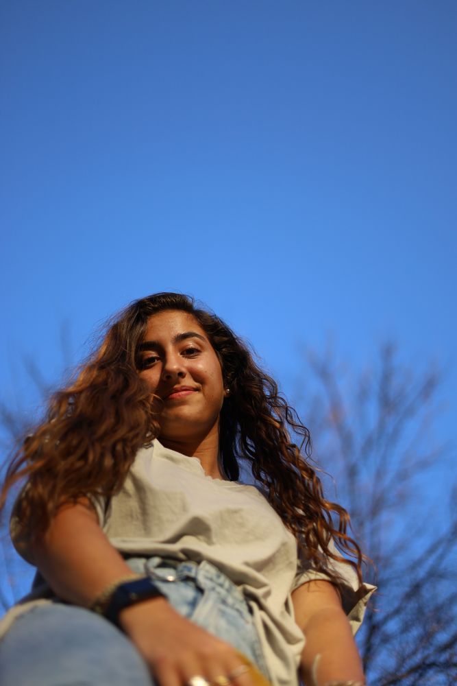 Woman photographed from below against a deep blue sky