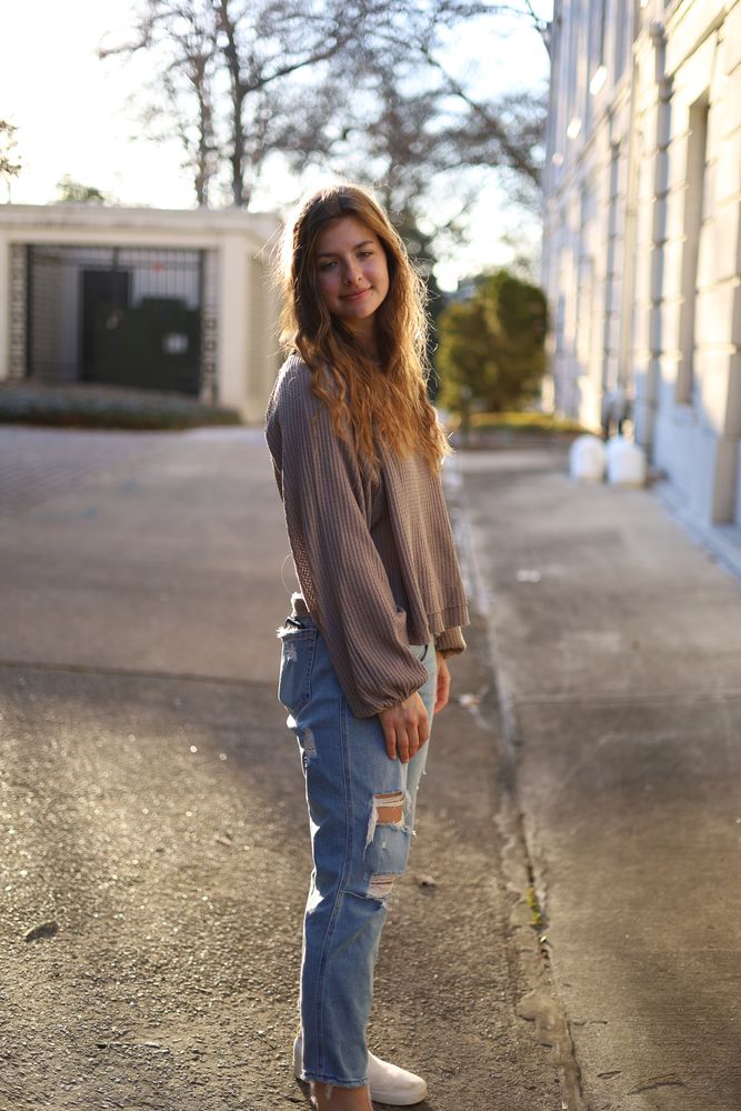 Woman standing on a sidewalk in evening light