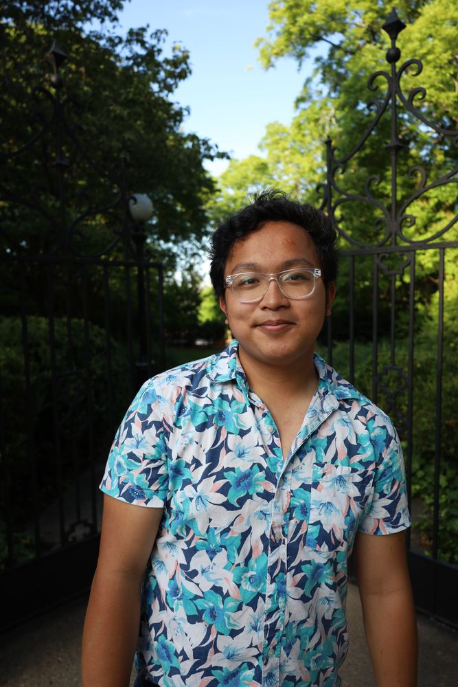 Smiling man in glasses in front of an iron gate