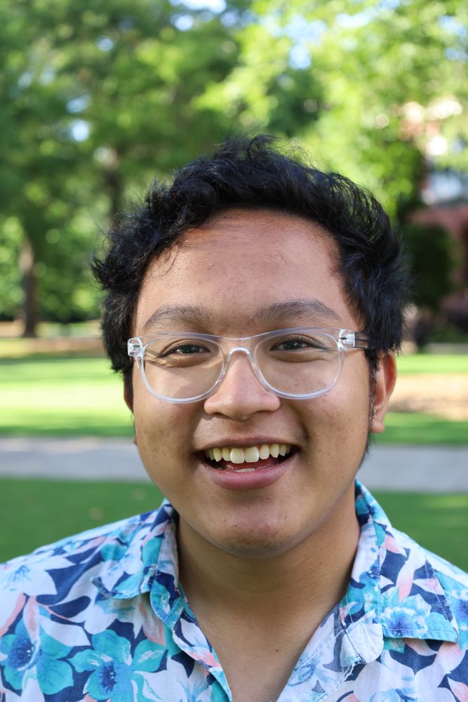 Close portrait of a laughing man in glasses and a floral shirt