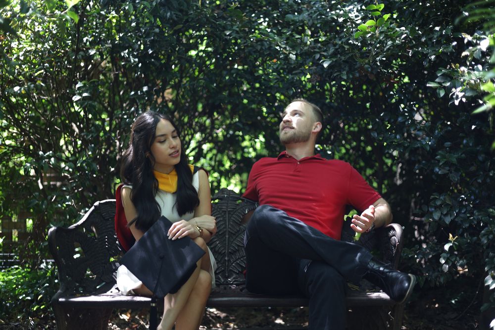 Graduate and her partner sitting on a garden bench