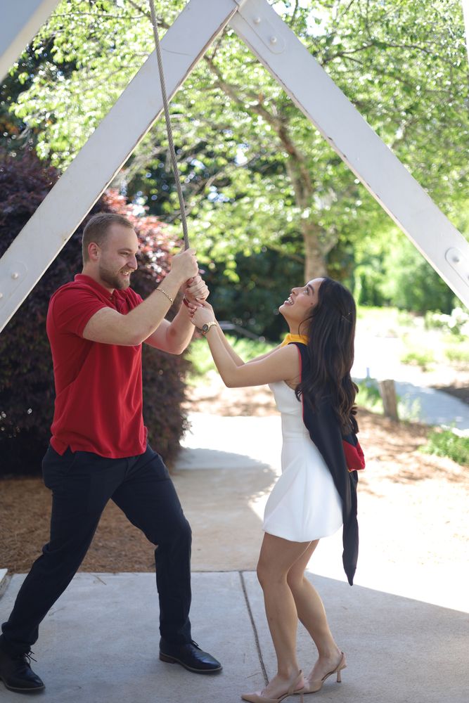 Graduate and her partner dancing under a trellis