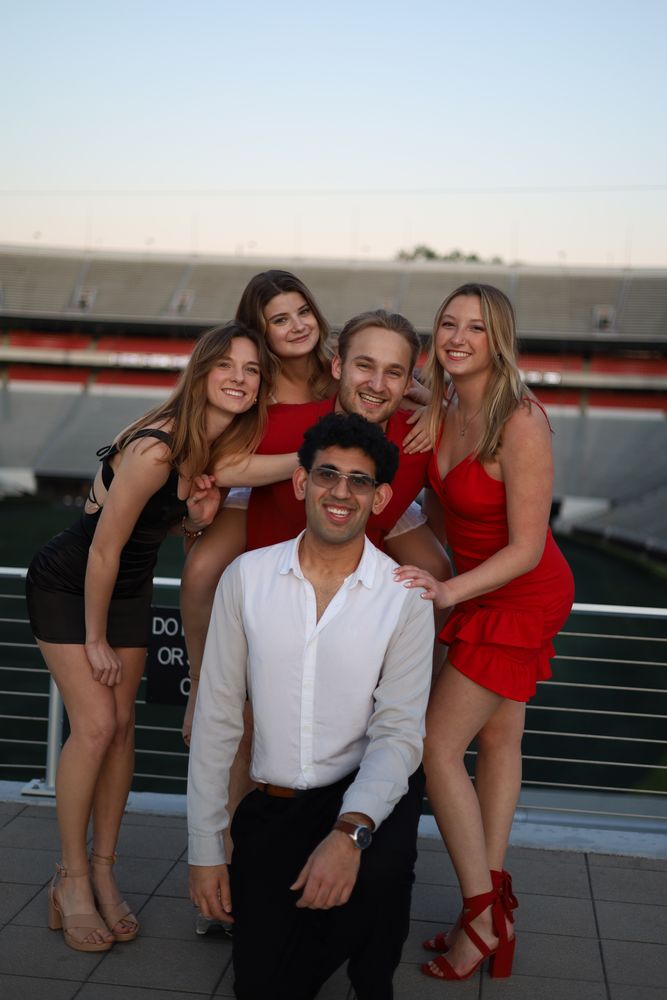 Group of friends posing together in a football stadium