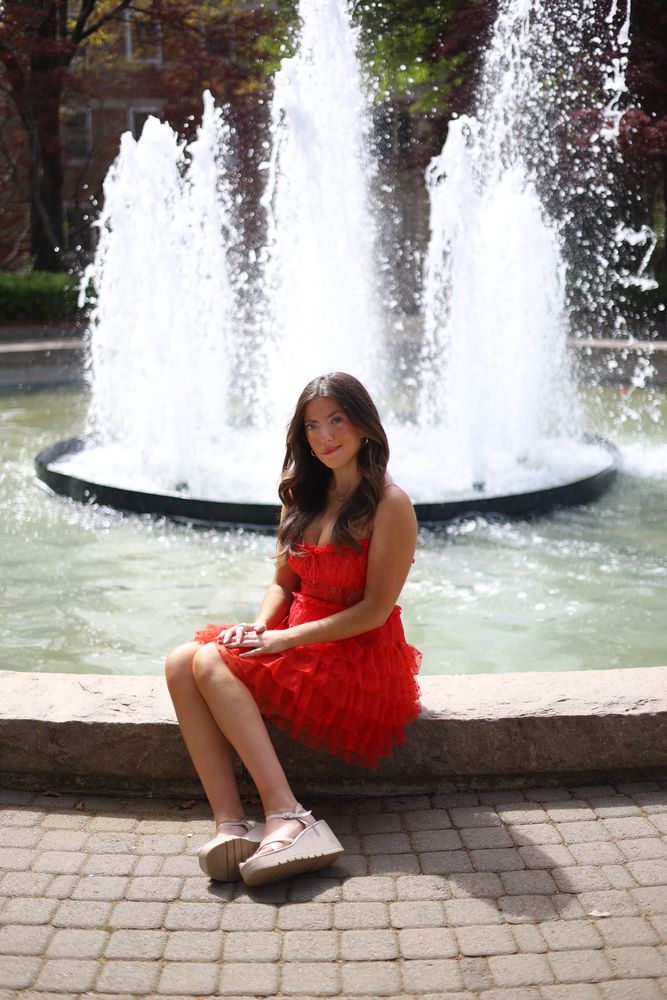 Graduate seated on the edge of a fountain