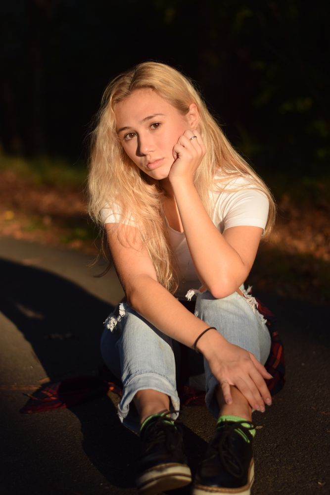Woman sitting in the road in the last light of the day