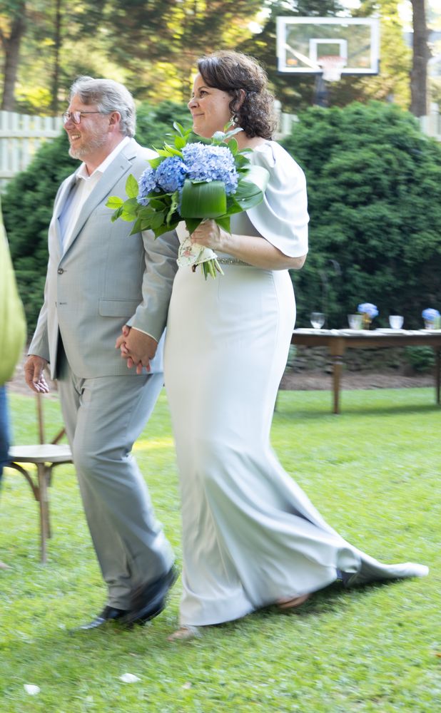 Bride and groom walking across the lawn