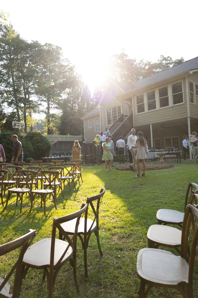 Empty ceremony chairs on a lawn in low sun