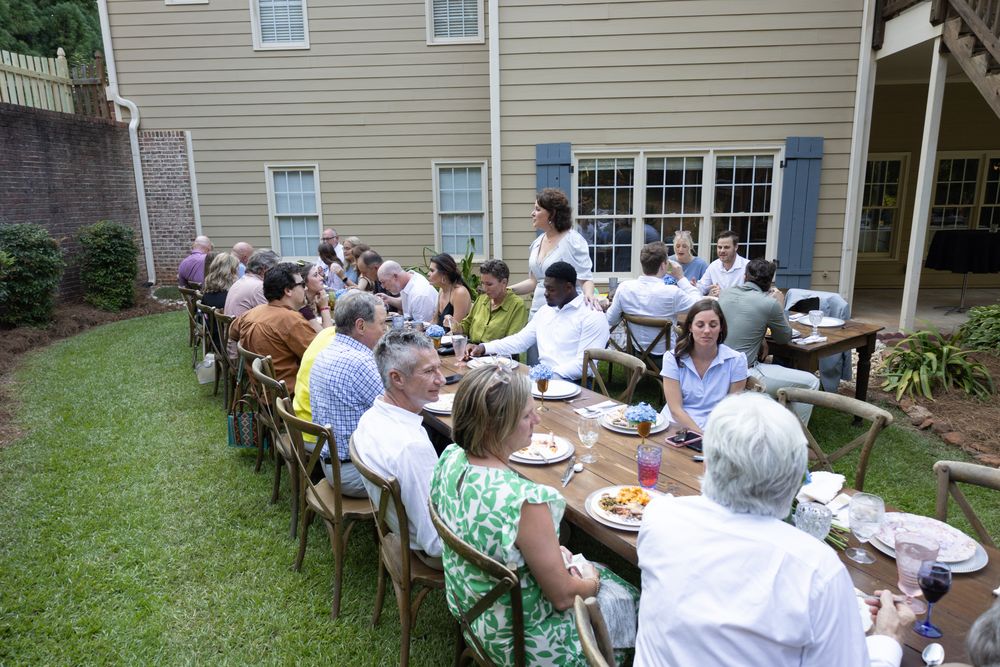 Guests at a long table in the backyard