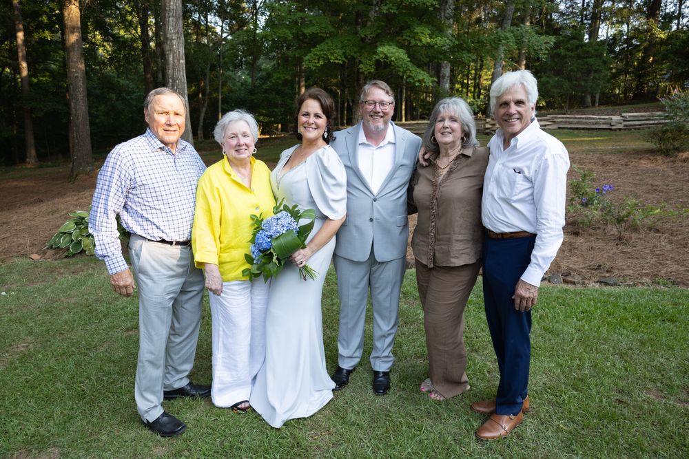 Wedding couple with family standing on the lawn